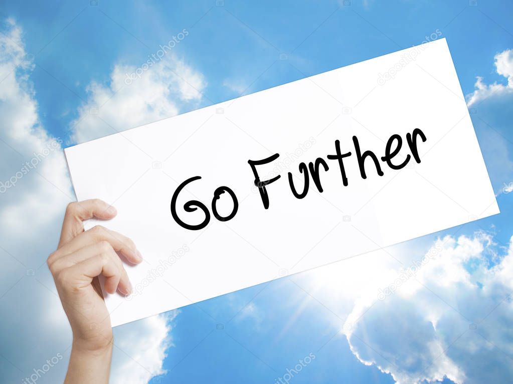 Go Further Sign on white paper. Man Hand Holding Paper with text