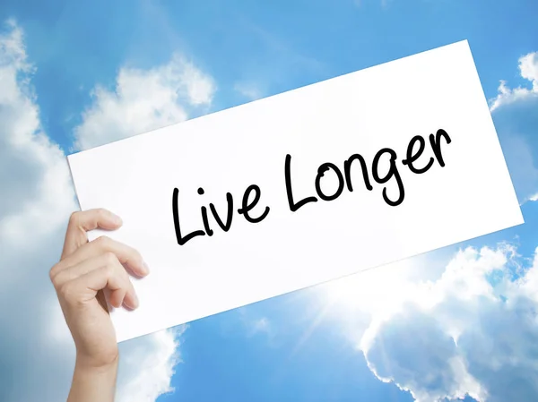 Live Longer Sign on white paper. Man Hand Holding Paper with tex — Stock Photo, Image