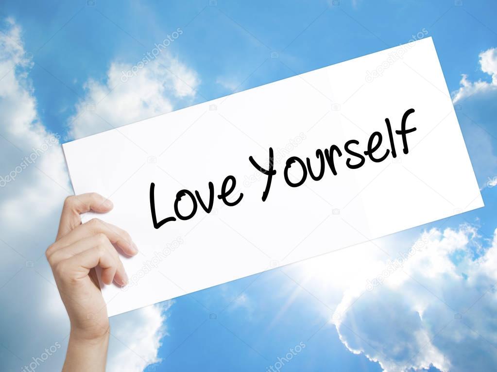 Love Yourself Sign on white paper. Man Hand Holding Paper with t