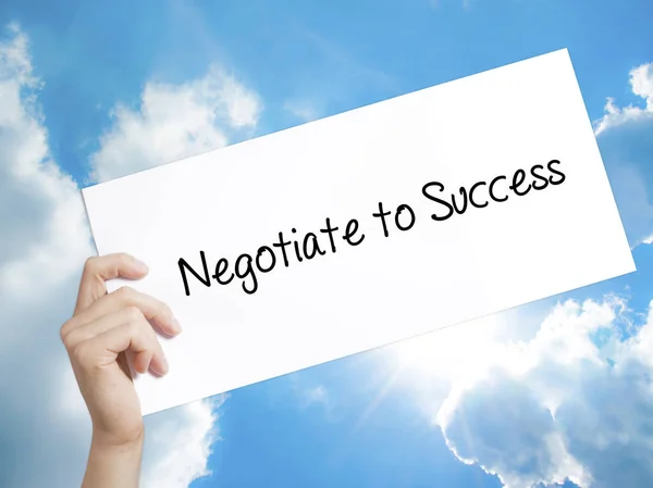 Negotiate to Success Sign on white paper. Man Hand Holding Paper