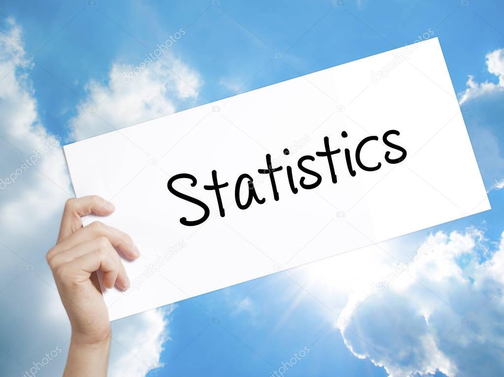 Statistics Sign on white paper. Man Hand Holding Paper with text