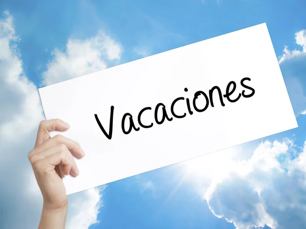 Знак Vacaciones (відпустку в Іспанська) на білому папері. Рука людини H — стокове фото