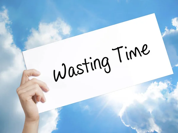 Wasting Time Sign on white paper. Man Hand Holding Paper with te — Stock Photo, Image