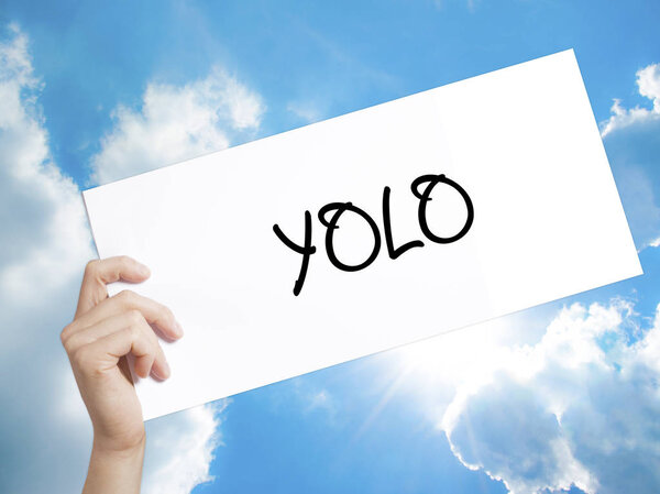 YOLO (You Only Live Once) Sign on white paper. Человек-холдинг
 