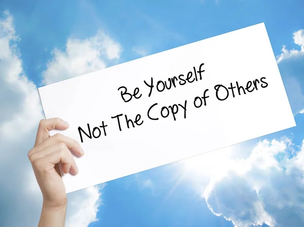 Be Yourself Not The Copy of Others Sign on white paper. Man Hand