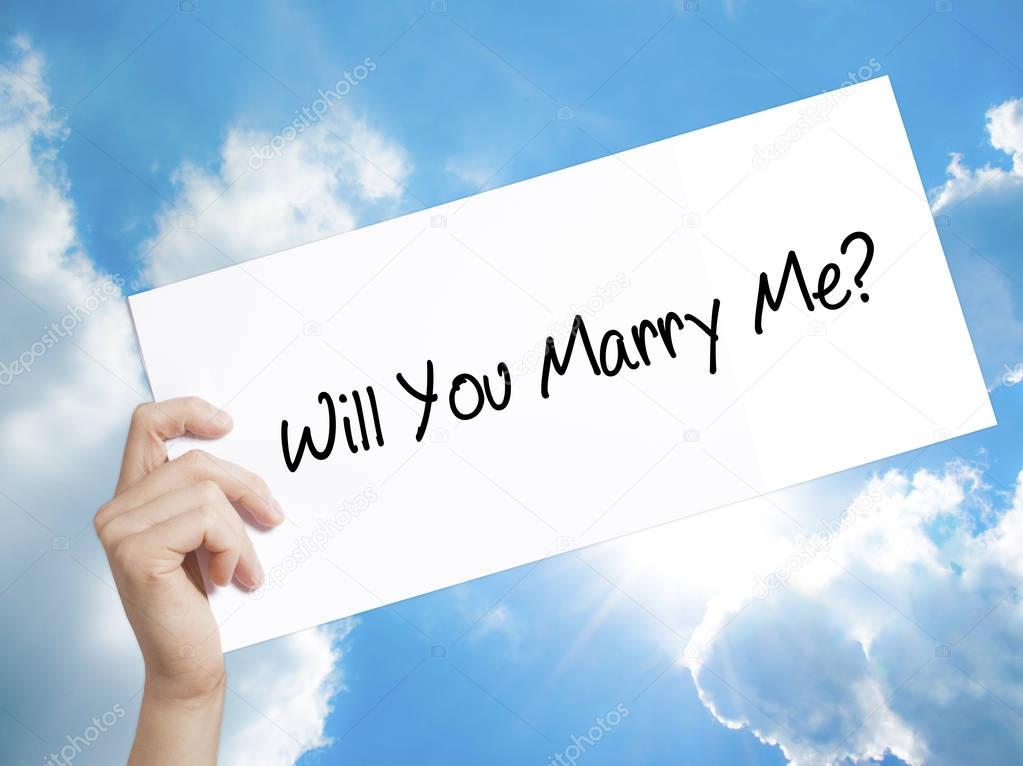 Will You Marry Me? Sign on white paper. Man Hand Holding Paper w