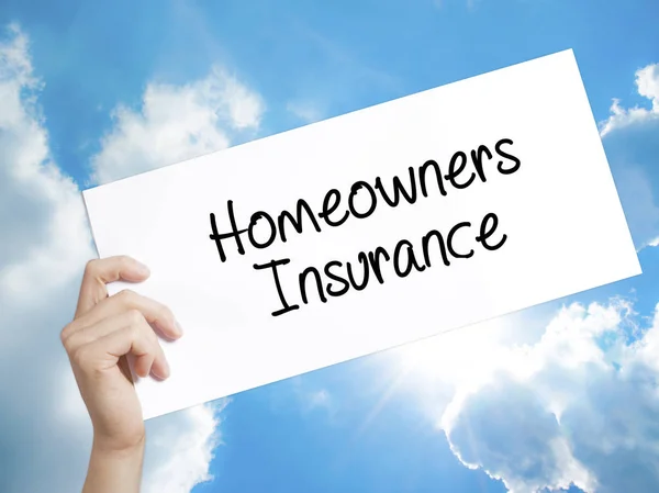 Homeowners Insurance Sign on white paper. Man Hand Holding Paper
