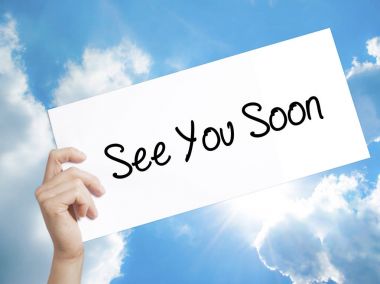See You Soon Sign on white paper. Man Hand Holding Paper with te clipart
