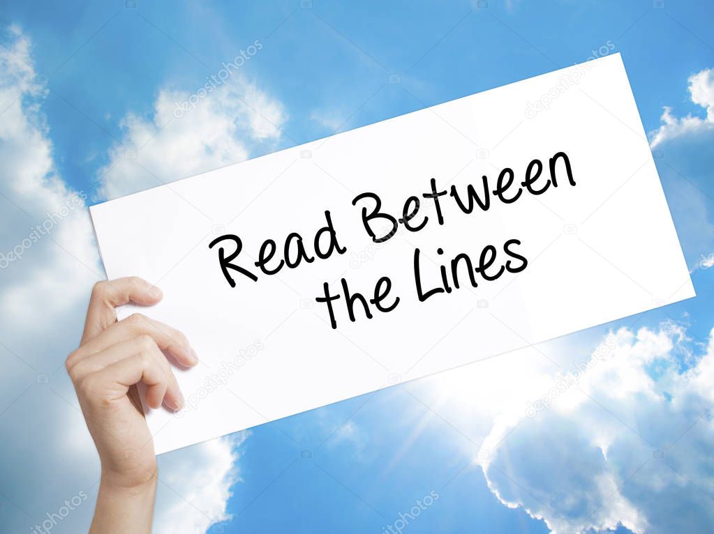 Read Between the Lines   Sign on white paper. Man Hand Holding P