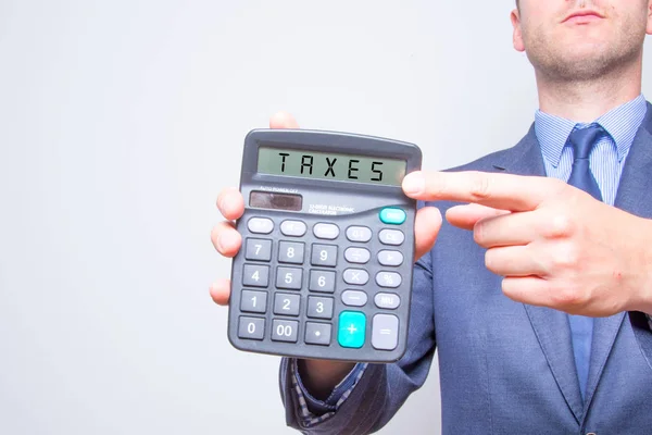 Joven hombre de negocios apuntando a la calculadora. Concepto de negocio de impuestos —  Fotos de Stock