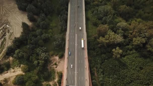Снимок с беспилотника: Вид транспортных средств, пересекающих длинный бетонный мост через реку — стоковое видео