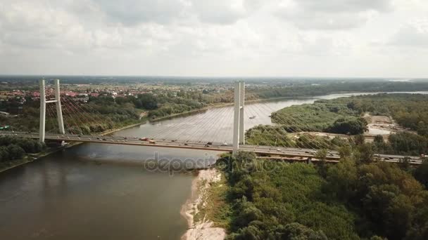 Tiro drone aéreo: voando em direção e sobre veículos que atravessam ponte rodoviária sobre um rio — Vídeo de Stock