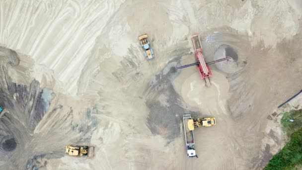 Graafmachine loader in zand steengroeve. Bekijk van bovenaf. Luchtfoto dumper vrachtwagens met lading zand ritten bewegen op grondgebied zand fabriek. Kipper vrachtwagens op industrieel gebied. Zand werk — Stockvideo