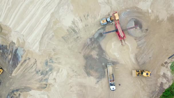 Baggerlader im Sandbruch. Blick von oben. Kipper mit Ladungssand fahren auf dem Gelände der Sandfabrik. Kipper auf dem Industriegelände. Sandarbeit — Stockvideo