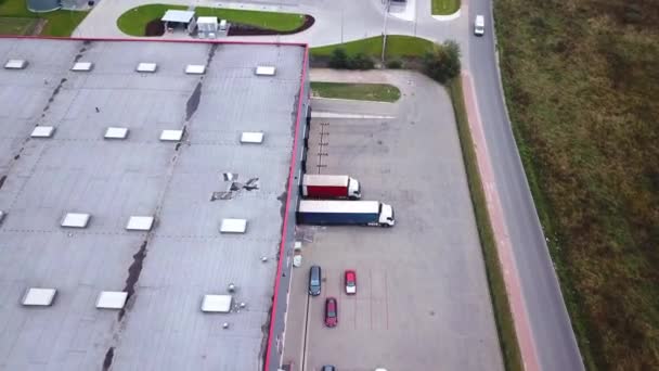Luftaufnahme von Industrielager / Lagerhalle / Ladefläche, wo viele LKW Waren be- / entladen — Stockvideo