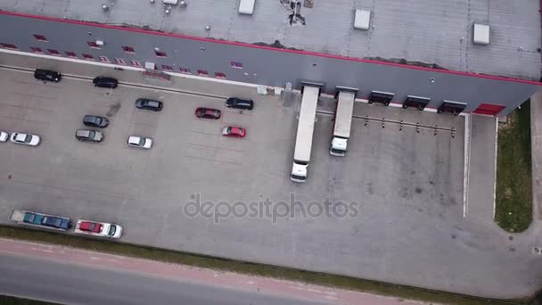 Εναέρια φωτογραφία της Βιομηχανική αποθήκη / αποθήκευσης κτίριο / φόρτωση περιοχή όπου πολλά φορτηγά για φόρτωση / εκφόρτωση εμπορευμάτων — Αρχείο Βίντεο