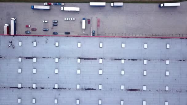 Přesun letecké boční záběr z průmyslového skladu nakládací rampy kde mnozí náklaďák s návěsy zatížení / uvolnění zboží. — Stock video
