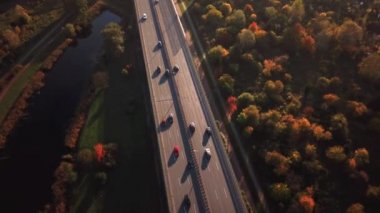 4k Hava: arabalar ve yarı kamyon meşgul karayolu üzerinde ülke çapında güzel sonbahar akşam sürüş. İnsanlar meşgul Çevre yolunda altın günbatımında seyahat yolculuğa