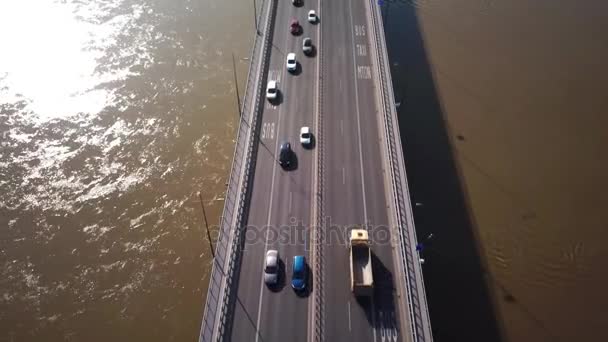 Воздушный кадр фокусируется на движении на мосту. Машины за рулем. Машины, пересекающие мост. 4К. Сияние солнца — стоковое видео