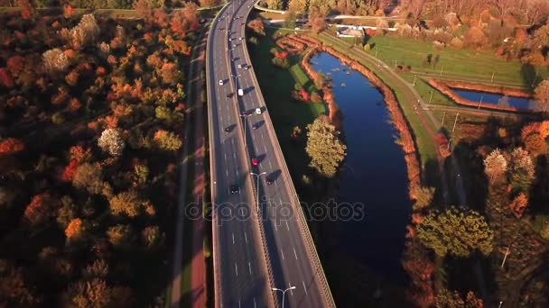 AÉRIEN 4K : Voitures et semi-camion conduisant sur l'autoroute achalandée à travers le pays dans la belle soirée d'automne. Les gens sur la route voyageant sur l'autoroute occupée au coucher du soleil doré 
