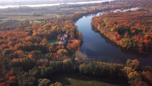 Vista aérea: Castelo junto ao rio. Voo sobre belo castelo; localizado no parque paisagístico com árvores verdes florestas no outono. 4K — Vídeo de Stock
