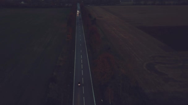 Lone car on highway road at twilight, aerial perspective with fog landscape in background. 4K UHD — Stock Video