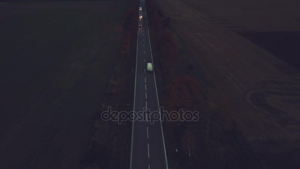 Lone auto op de snelweg weg bij avondschemering, antenne perspectief met mist landschap op achtergrond. 4k Uhd — Stockvideo