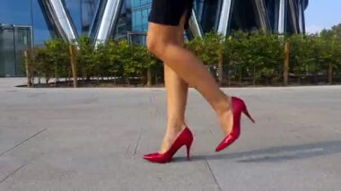 Yüksek topuklu ayakkabılı kadın bacakları şehir caddesinde yürüyor. Şehirdeki yüksek topuklu ayakkabılı genç iş kadınının ayakları. İşe giden bir kız. Yavaş çekim. Yakın çekim.