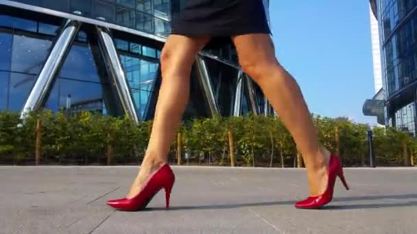 Sexy woman legs in red high heels shoes walking in the city urban street. Steadicam stabilized shot  Lens flare. Female legs in high-heeled shoes in the morning street. — Stock Video