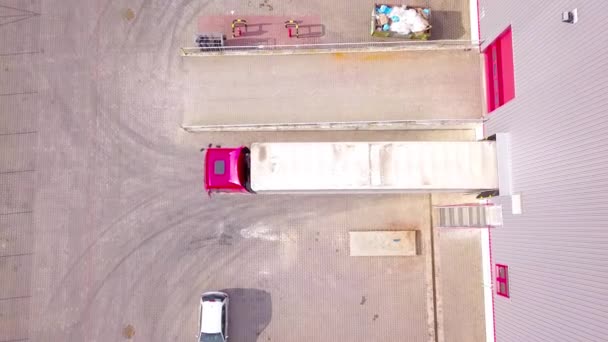 Aerial skott av lastbil med bifogade Semi Trailer lämnar industriella lager / lagring byggnad / lastning område där lastbilar Load / Unload Merchandise. arkivfilmer — Stockvideo