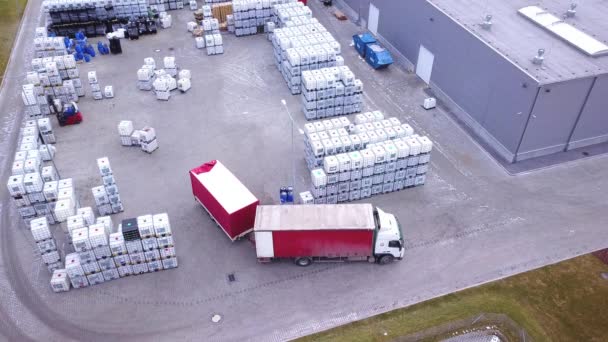 Truckar flytta mellan stora hyllor på utanför lager och lasta pallar. Antenn. Drone skott — Stockvideo