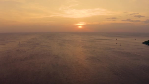 Orange solnedgång över havet. Solen går ner över horisonten. Kvällsutsikt över bergen och havet. Stora Cumulus moln i himlen. Vacker utsikt uppifrån. — Stockvideo