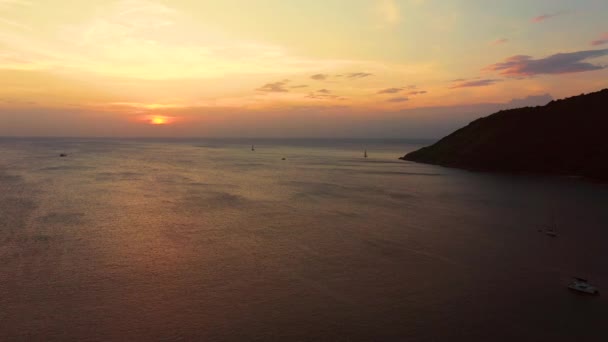 Puesta de sol naranja sobre el mar. El sol se está poniendo sobre el horizonte. Vista nocturna de las montañas y el mar. Grandes nubes de cúmulos en el cielo. Hermosa vista desde arriba . — Vídeos de Stock