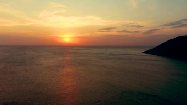 Puesta de sol naranja sobre el mar. El sol se está poniendo sobre el horizonte. Vista nocturna de las montañas y el mar. Grandes nubes de cúmulos en el cielo. Hermosa vista desde arriba . — Vídeo de stock