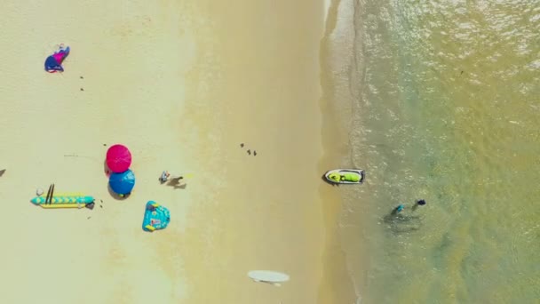Aéreo: Voe para fora da bela praia. PHUKET, THAILAND Praia de Patong. praia de areia e água azul transparente. Guarda-chuva. Scooter de água — Vídeo de Stock