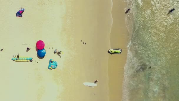 Aerial: Leć z pięknej plaży. Phuket, Tajlandia Plaża Patong. piaszczysta plaża i błękitna przezroczysta woda. Parasol. Skuter wodny — Wideo stockowe