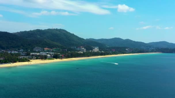 Tropikal turkuaz körfezde yüksek hızda seyreden sürat teknesi donut su sporlarının insansız hava aracı fotoğrafı. Tayland, Phuket, Kata Sahili — Stok video