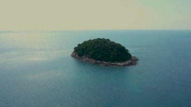 Taşlı sahilleri ve yeşil ormanlarıyla tropik adaya doğru uç. Yoğun çalılıkların ortasında palmiye ağaçları taç taksın. Tayland, Phuket Adası yakınlarındaki doğa manzarası. Ko Pu.