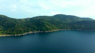 Tropikal tatil köyü ve plajdan oluşan hava manzarası, Phuket Adası 'nın batı kıyısındaki güzel Andaman denizi. Yukarıdan Kata Noi plajı, bazı binalar ve yeşil tepeler, ufuktan ufka sakin deniz yüzeyi