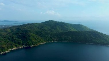 Tropikal tatil köyü ve plajdan oluşan hava manzarası, Phuket Adası 'nın batı kıyısındaki güzel Andaman denizi. Yukarıdan Kata Noi plajı, bazı binalar ve yeşil tepeler, ufuktan ufka sakin deniz yüzeyi