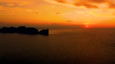 Phi Phi Adaları panoraması, Krabi Eyaleti, Tayland / Tayland. Deniz ve adalar üzerinde muhteşem bir gün batımı. Tropiklerde inanılmaz bir alacakaranlık ve sakin Hint okyanusu. Havadan