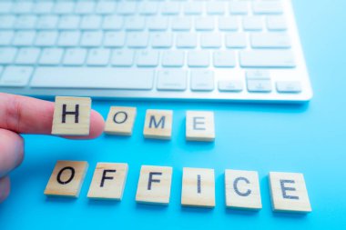 Ev işleri ev yapımı ahşap harflerle yapılır. Ve klavye arka plan mavisinin yanında.