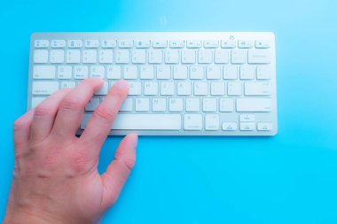 Evde bilgisayarcıyla blog yazarken. Adam elleri klavyede.