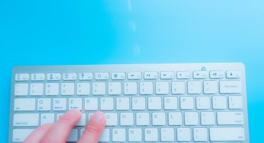 Evde bilgisayarcıyla blog yazarken. Adam elleri klavyede.