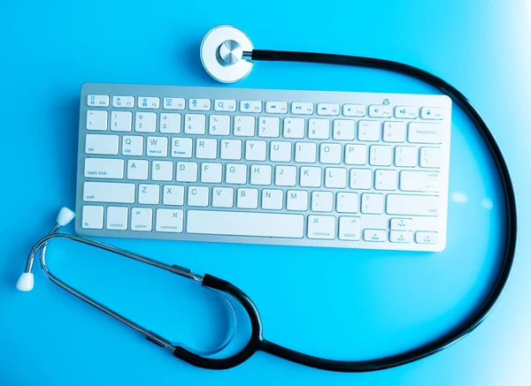 Computer system health or auditing - Stethoscope over a computer keyboard toned in blue