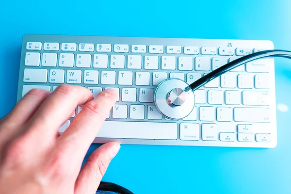 Computer system health or auditing - Stethoscope over a computer keyboard toned in blue