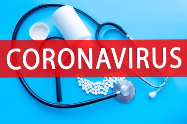 COVID-19 kavramı. Coronavirus hastalığı. Üzerinde COVID-19 yazan mavi arkaplanda stetoskop yakın plan fotoğrafı. Yakın çekim.