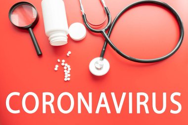Kırmızı pastel arka planda Coronavirus şırınga gözlüğü ve steteskop ifadesi. Roman Coronavirus 2019-nCoV MERS-Cov Covid-19 Orta Doğu Solunum Sendromu Coronavirus virüs aşısı konsepti
