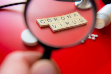 Coronavirus COVID-19 konsept görüntü nükteli metni büyüteçle görülüyor. Kırmızı Arkaplan