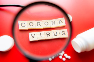 Coronavirus COVID-19 konsept görüntü nükteli metni büyüteçle görülüyor. Kırmızı Arkaplan